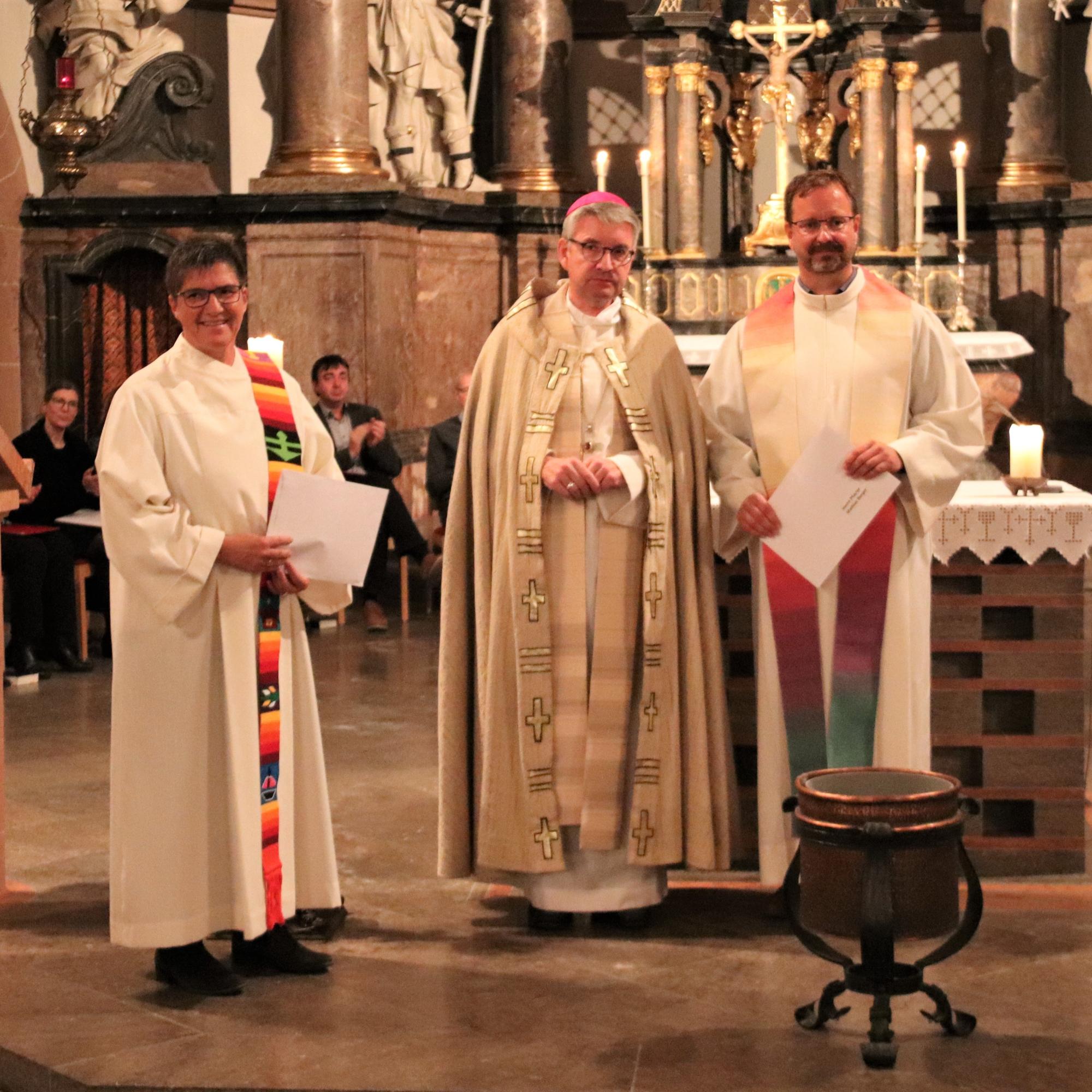 Bischof Peter Kohlgraf überreichte die Dekrete ihrer offiziellen Ernennung zu Beauftragten der queersensiblen Pastoral an Christine Schardt und Mathias Berger