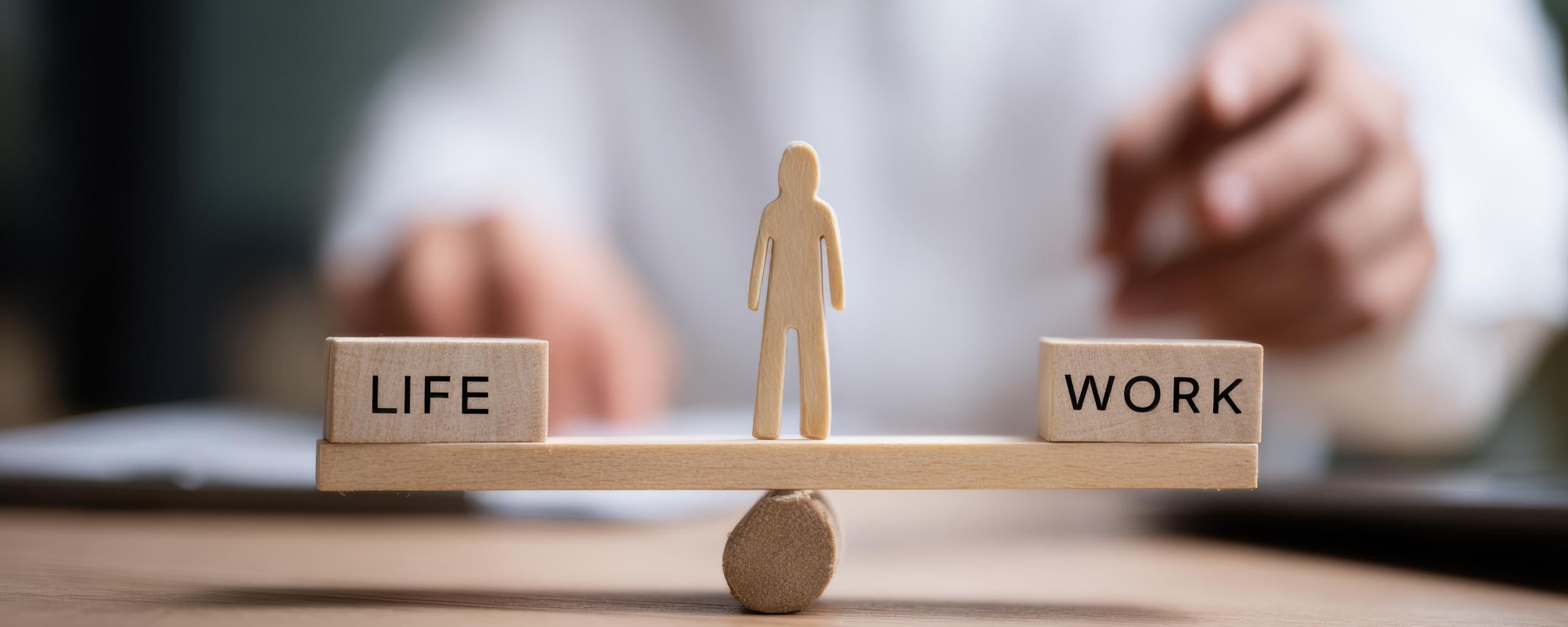 Waage mit Life und Work, in der Mitte ein Mensch