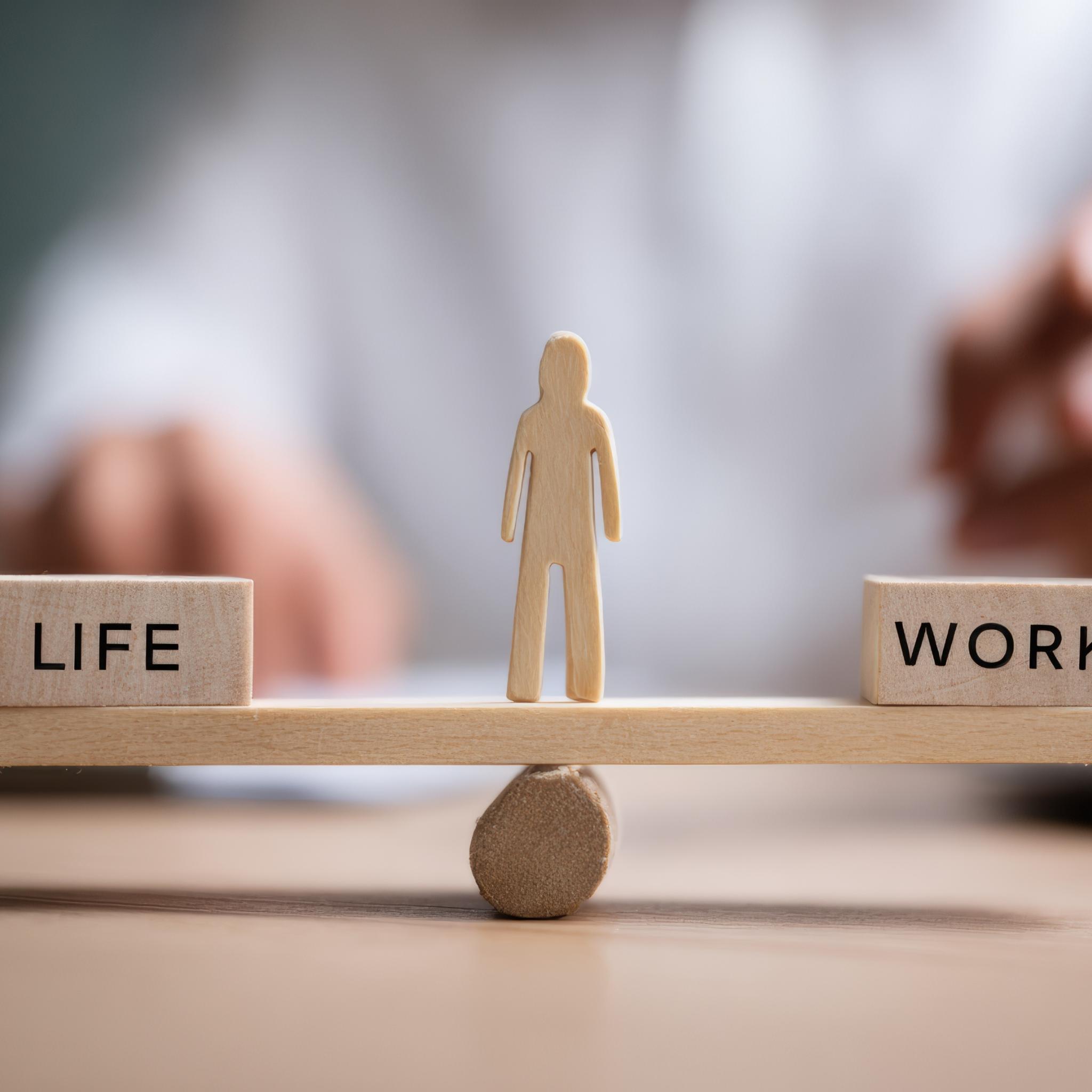Waage mit Life und Work, in der Mitte ein Mensch