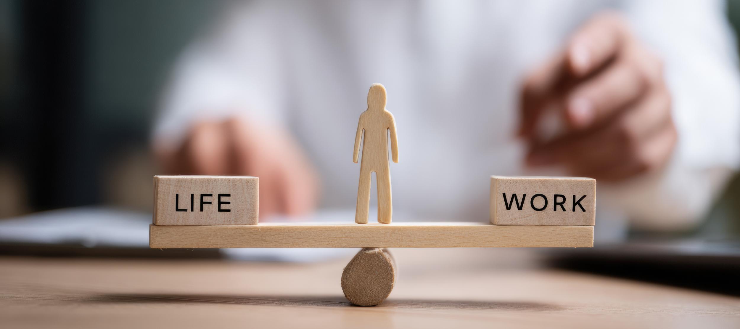 Waage mit Life und Work, in der Mitte ein Mensch