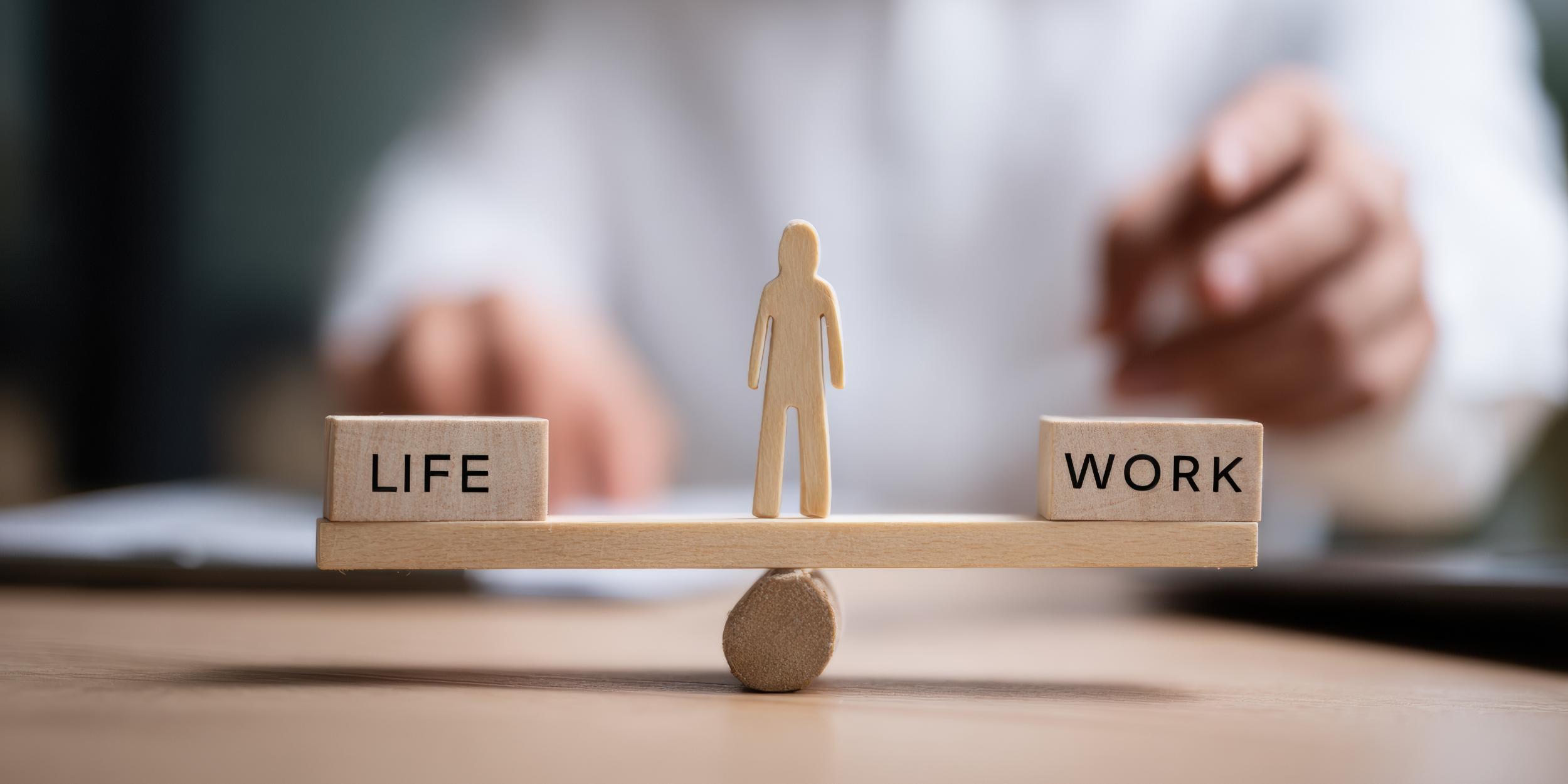 Waage mit Life und Work, in der Mitte ein Mensch