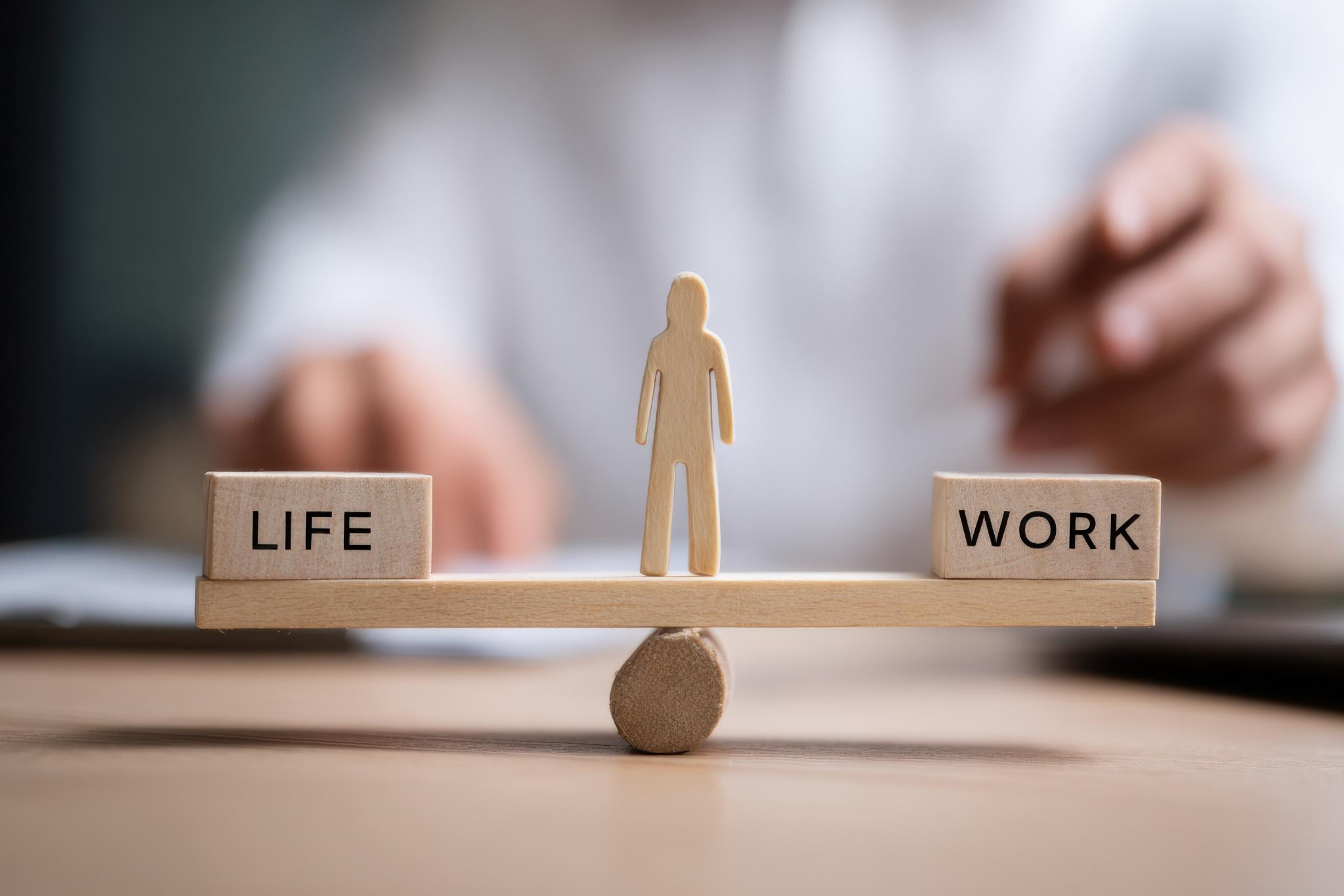 Waage mit Life und Work, in der Mitte ein Mensch