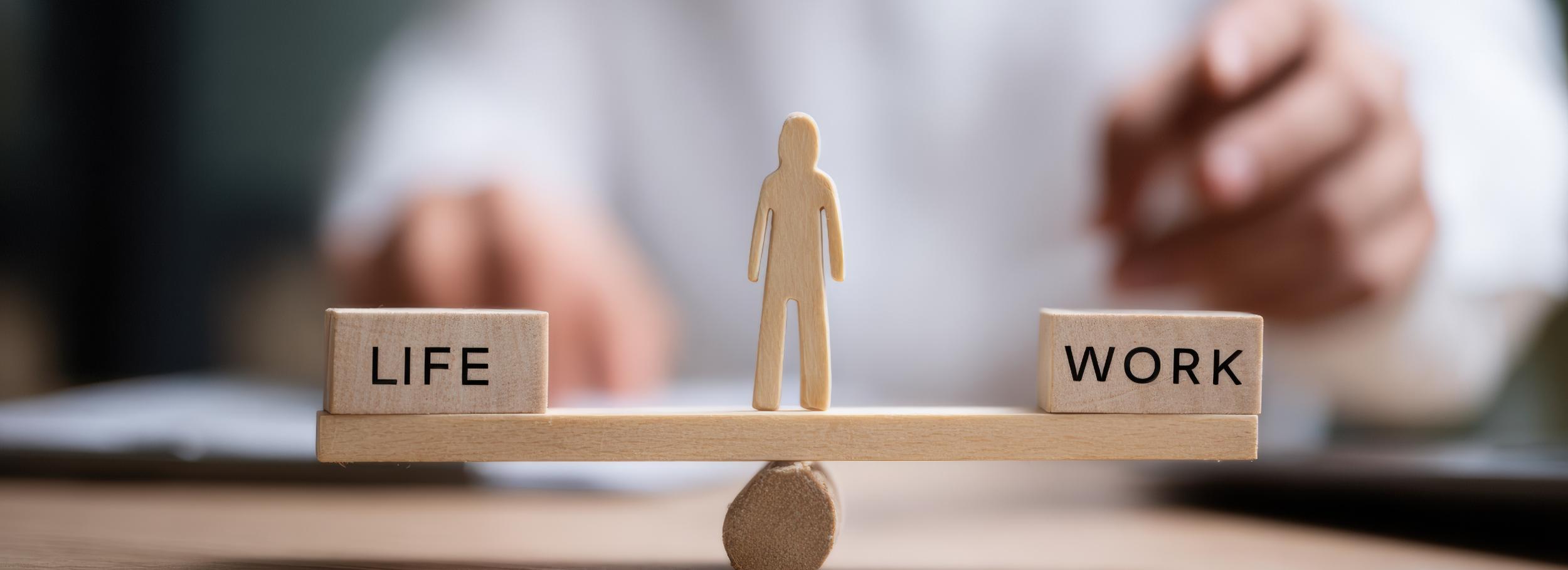 Waage mit Life und Work, in der Mitte ein Mensch