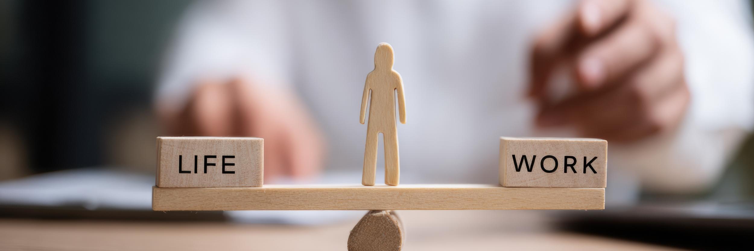 Waage mit Life und Work, in der Mitte ein Mensch