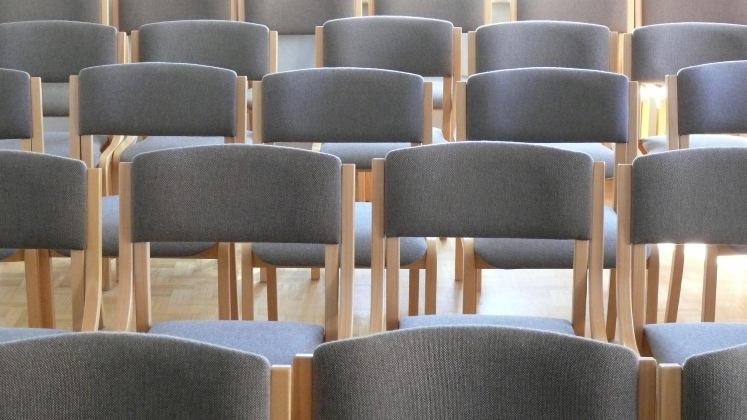 graue Stühle sind in mehreren Reihen hintereinander aufgestellt