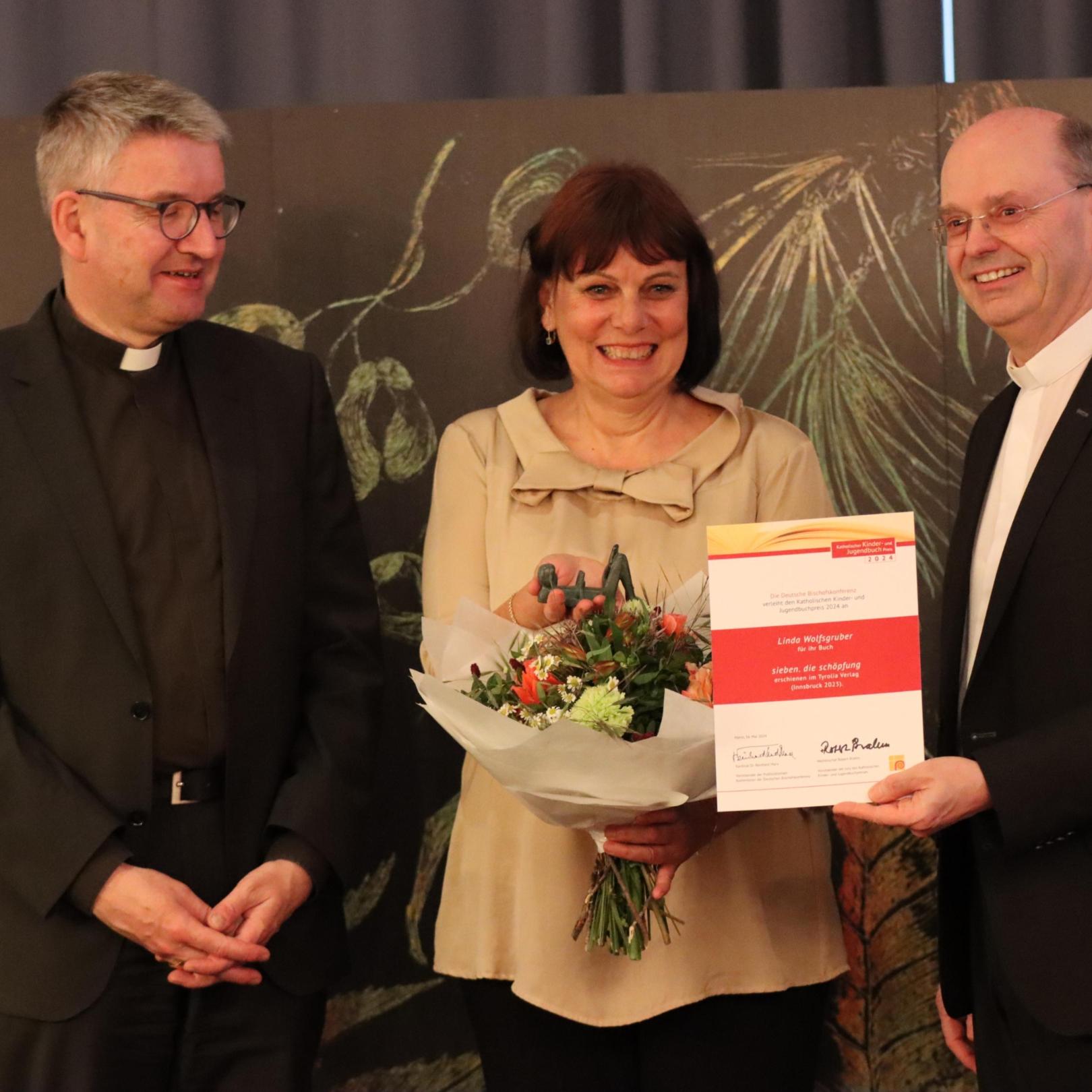 Die Preisträgerin Linda Wolfsgruber mit Bischof Peter Kohlgraf (li.) und dem Jury-Vorsitzenden Weihbischof Robert Brahm aus Trier
