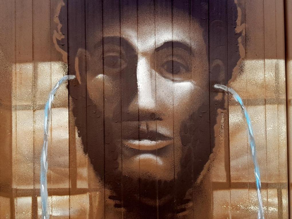 Kunstwerk eines Gesichts mit Wasser, das aus den Ohren fließt.
