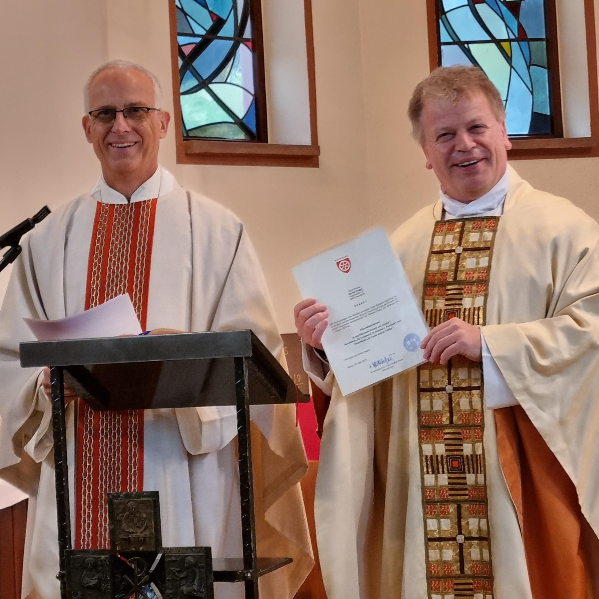 Domkapitular Hans-Jürgen Eberhardt (links) und Pfarrer Harald Poggel mit der Beauftragungsurkunde