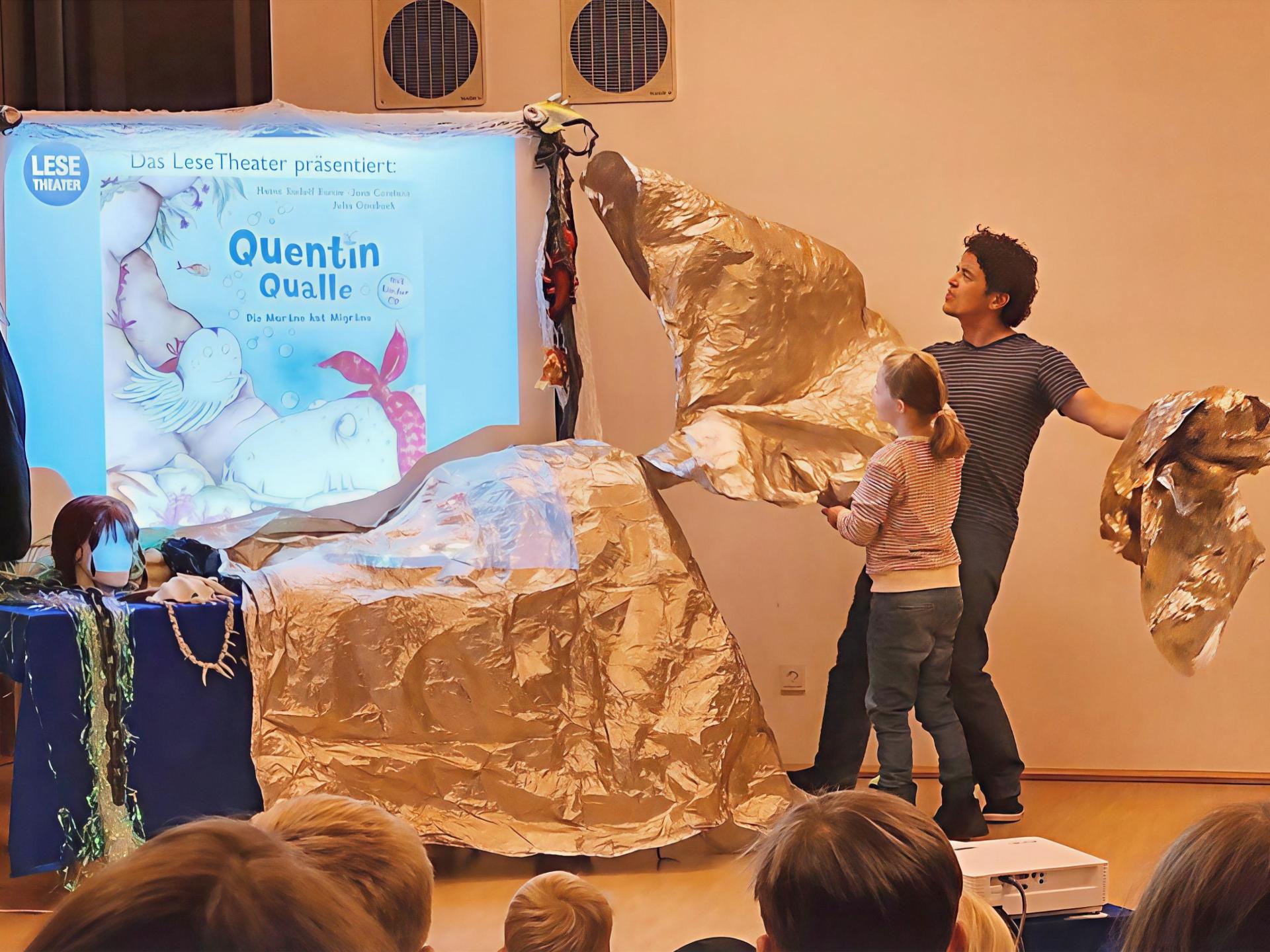 Titelbild Quentin Qualle mit 2 Personen enthüllen das Buchcover