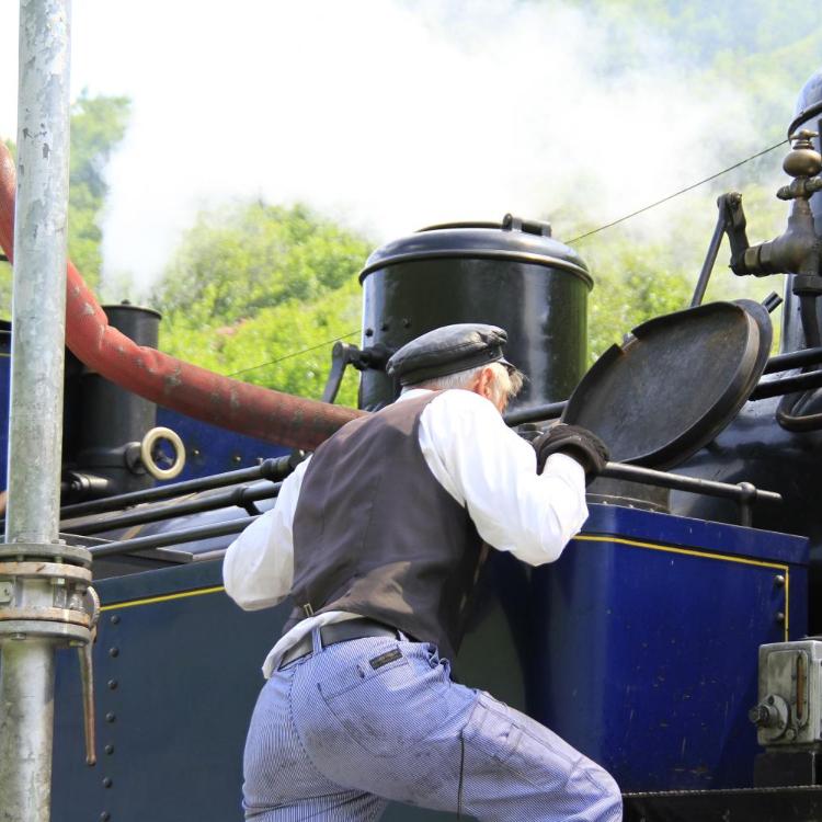 Mann inspiziert eine Dampflokomotive