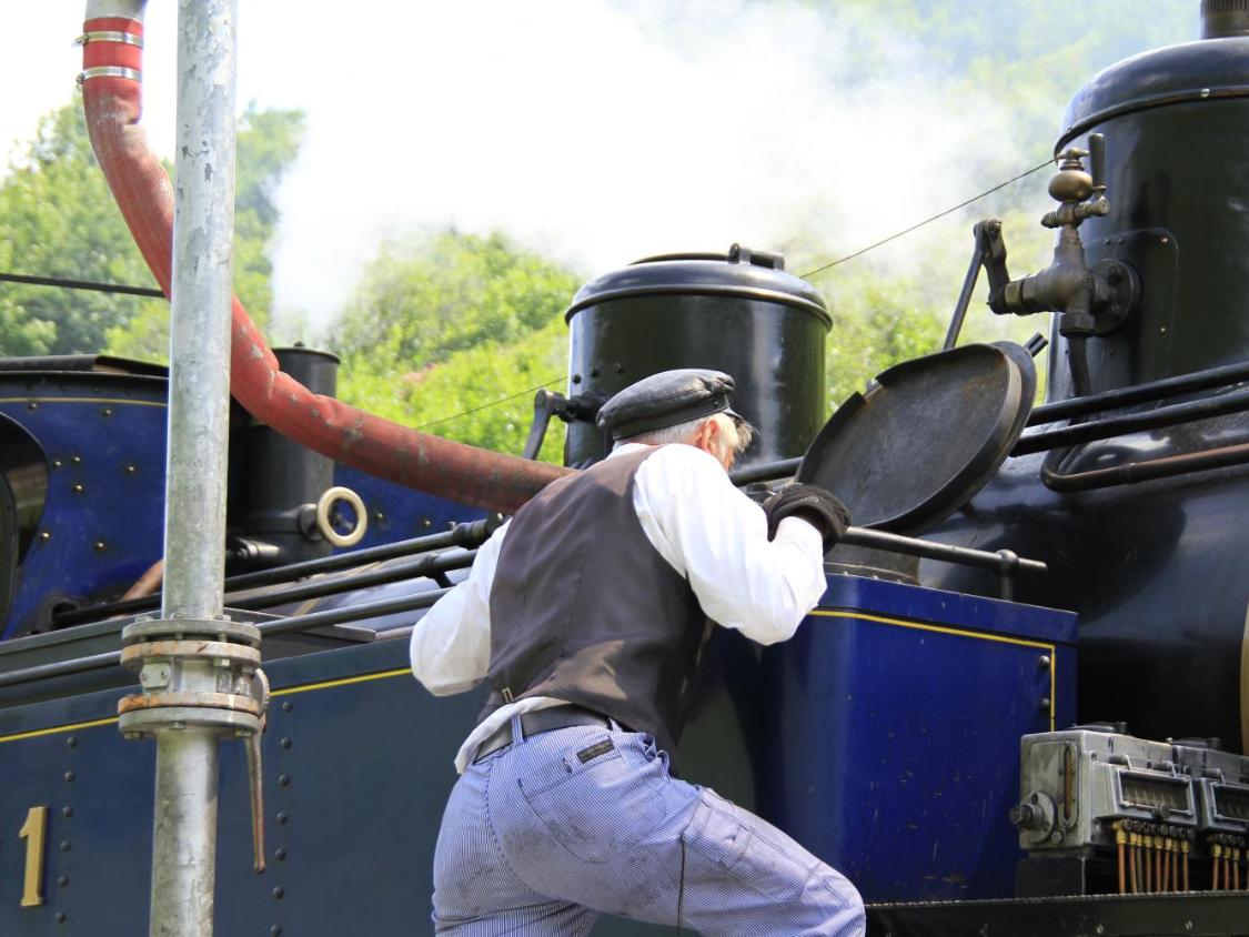 Mann inspiziert eine Dampflokomotive