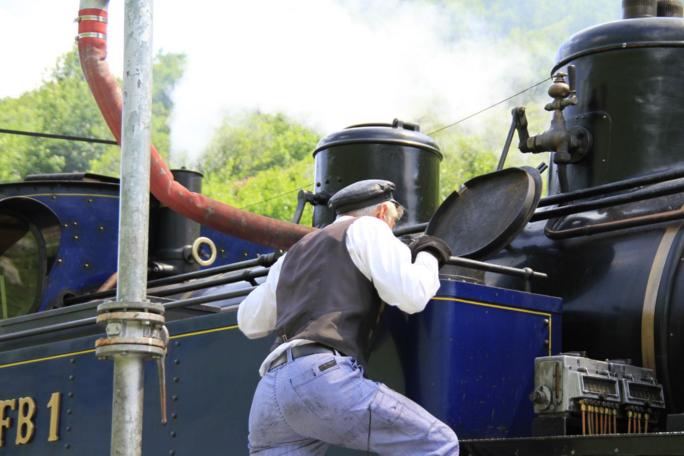 Mann inspiziert eine Dampflokomotive