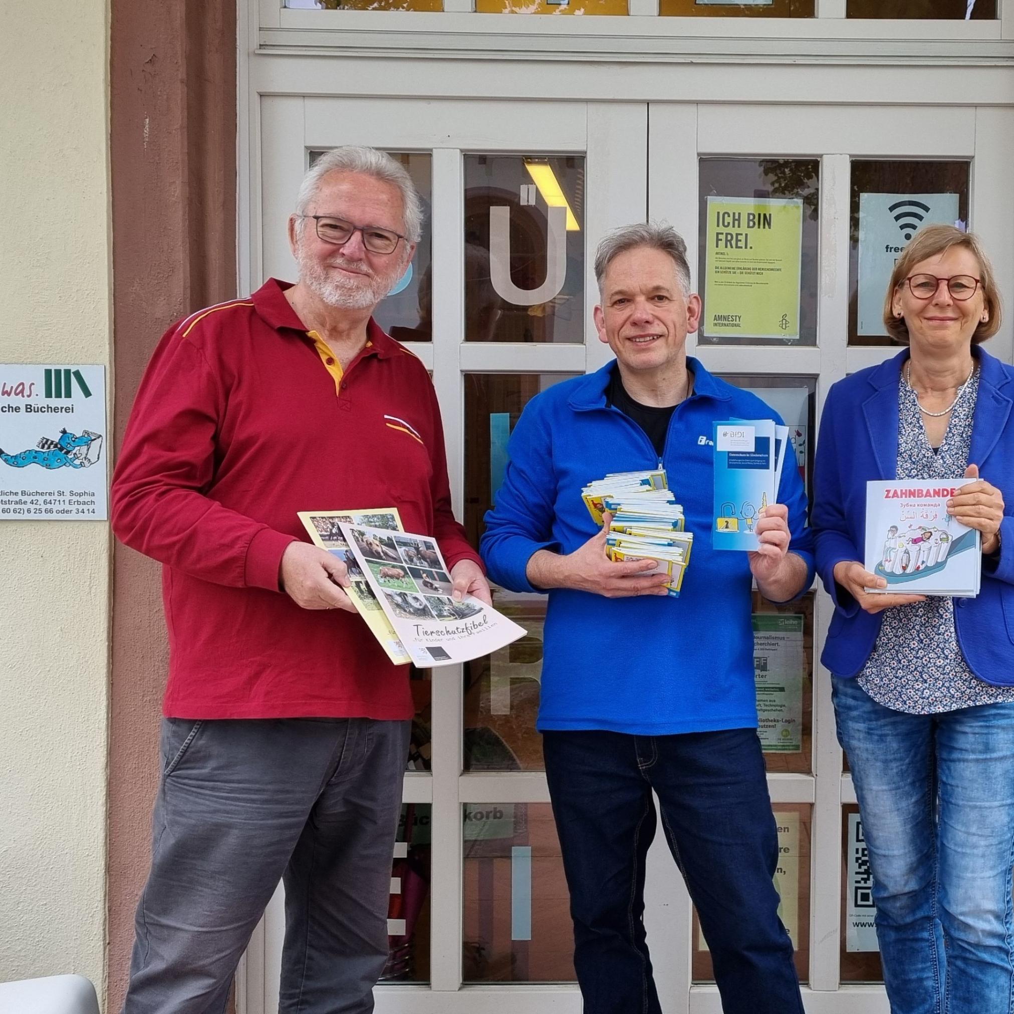 Vor der Bücherei St. Sophia trafen sich zur Medienübergabe: (v.l.) Willi Weiers vom Bücherei-Team, Carsten Rohmann und Brigitte Wittmann vom Caritas Familienzentrum