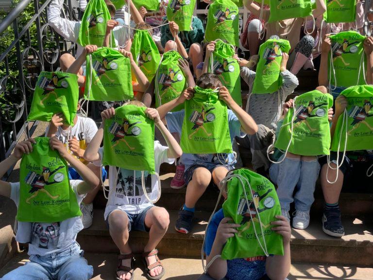 Gruppenbild mit Kindern mit grünen Taschen