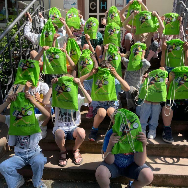 Gruppenbild mit Kindern mit grünen Taschen