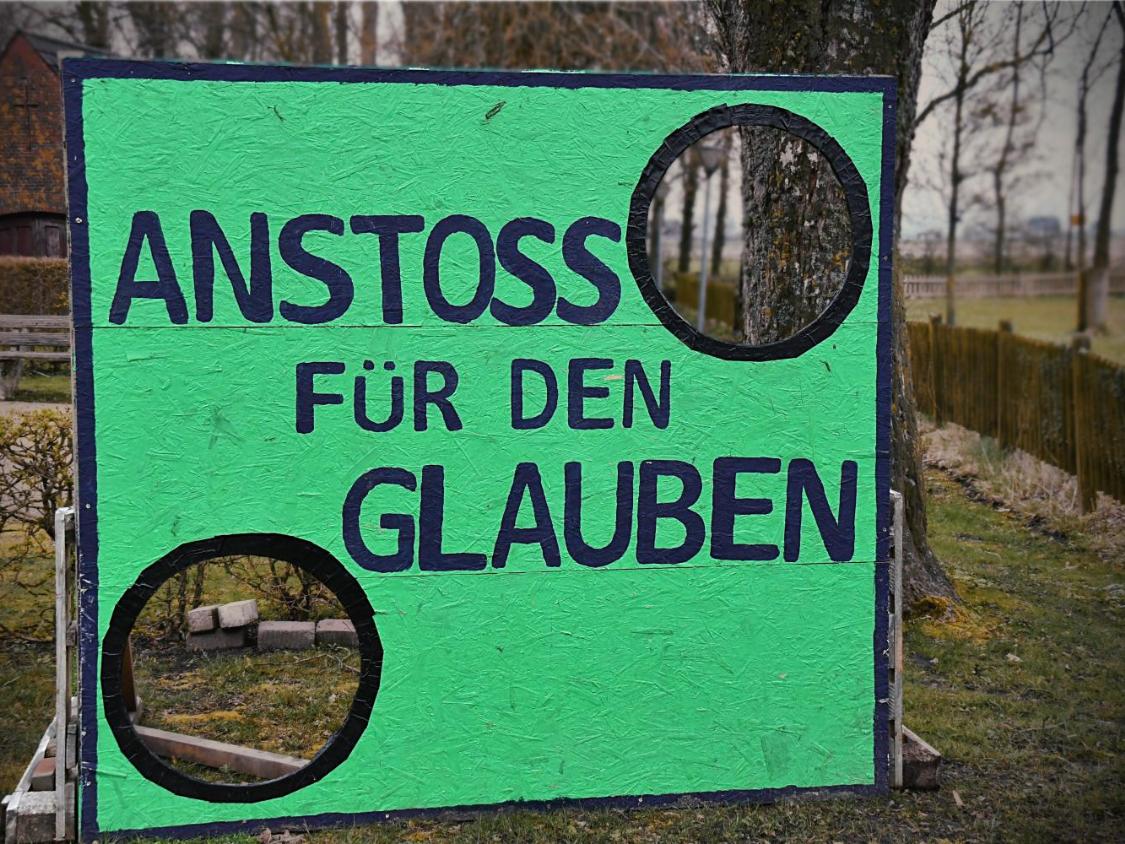 Grüne Torwand mit dem Text 'Anstoss für den Glauben'
