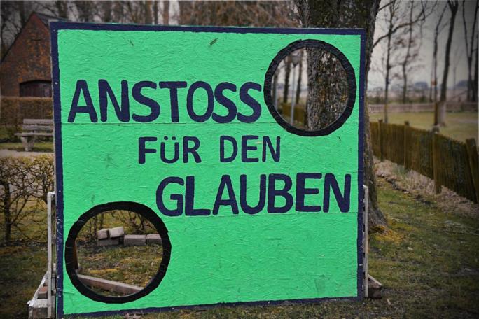 Grüne Torwand mit dem Text 'Anstoss für den Glauben'