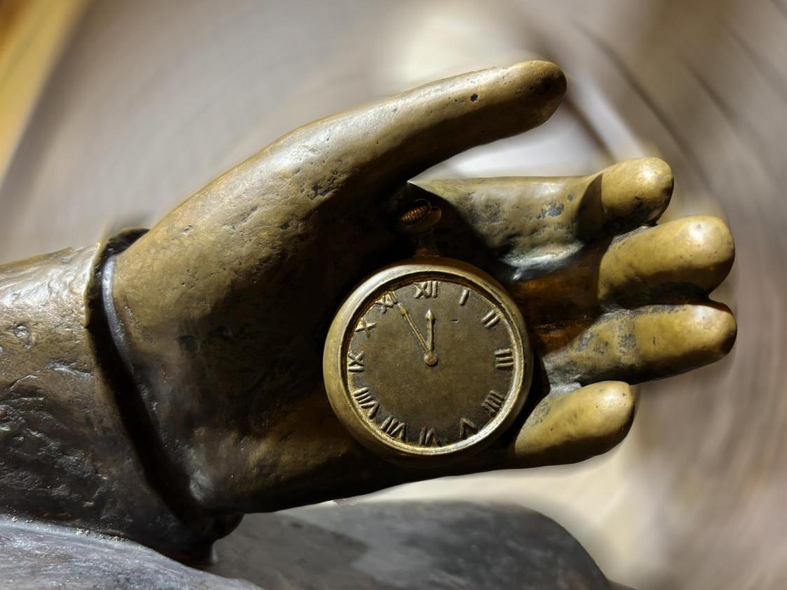 Metallene Skulptur einer Hand mit Taschenuhr