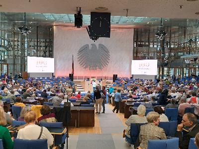 Mit Teilnehmerinnen und Teilnehmern gefüllter Plenarsaal des Alten Bundestages in Bonn beim Festakt 100 Jahre Buchsonntag. Im Hintergrund der Bundesadler an der Wand.