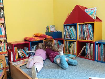 Kleine Kinder beim Lesen in der Bücherei