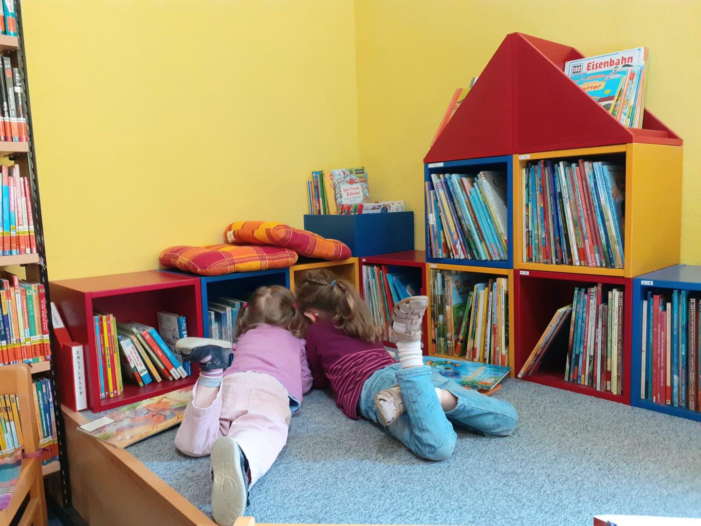 Kinder beim Stöbern in der Bücherei (c) Fachstelle Mainz/M.Schneider