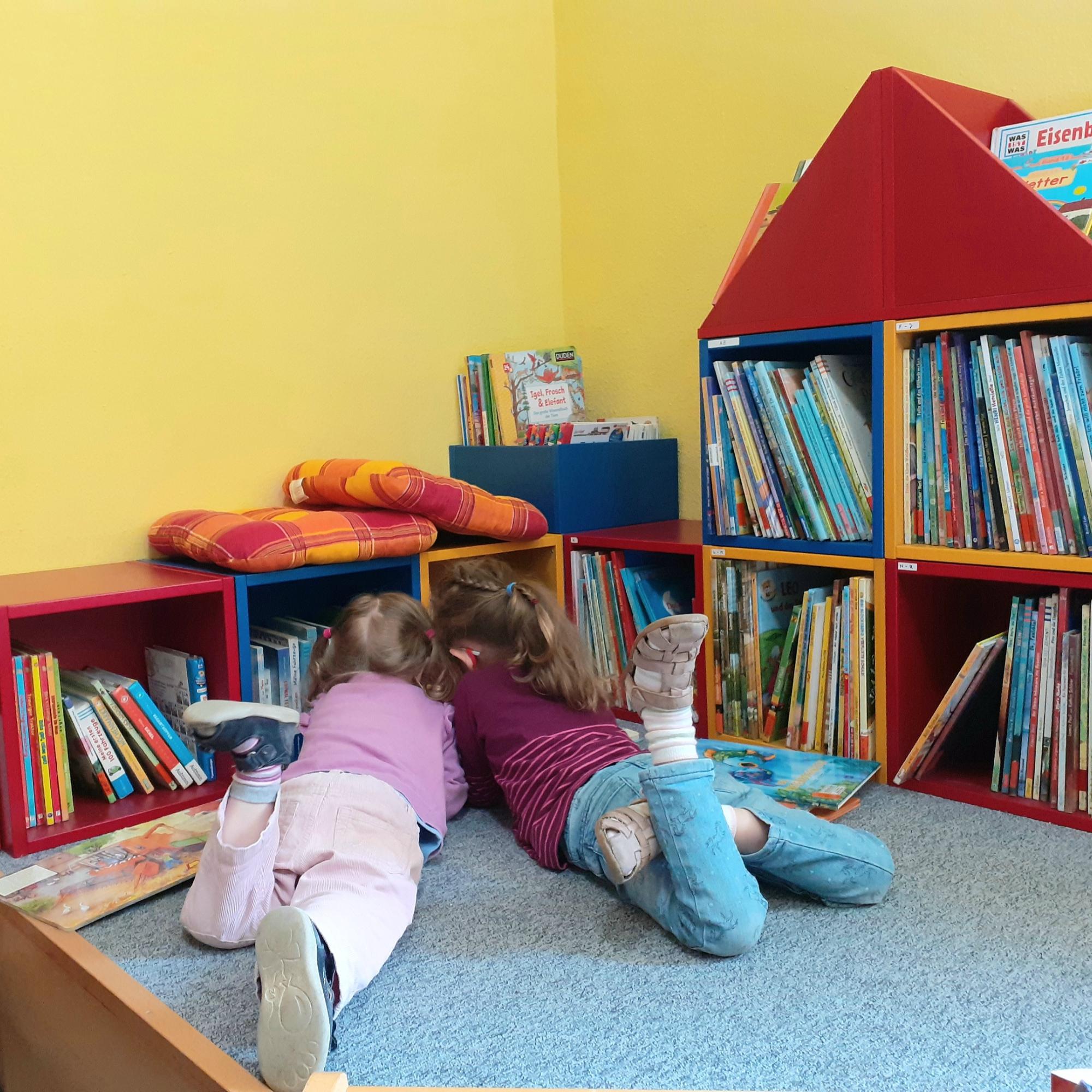 Kinder beim Stöbern in der Bücherei