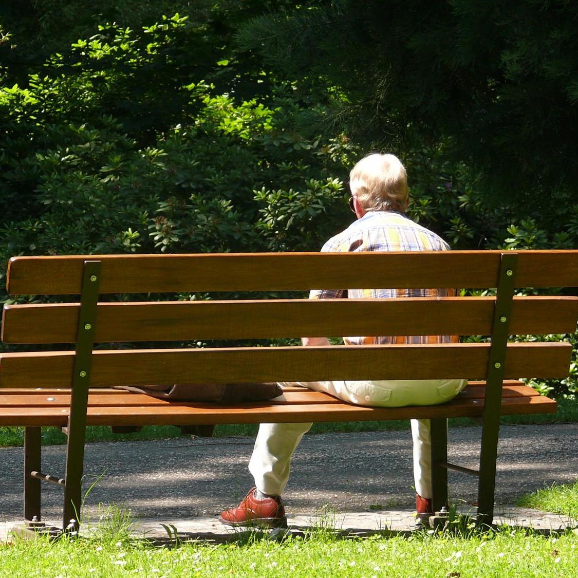Mann sitzend auf einer Parkbank