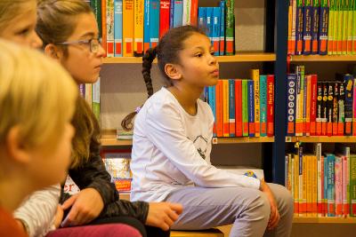 Kinder hörend beim Vorlesen in Bücherei