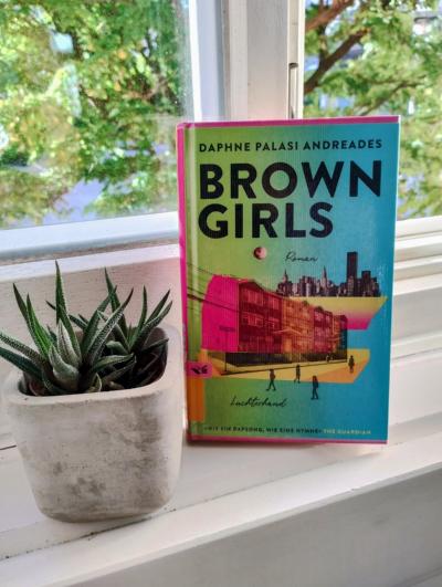 Buch Brown Girls steht auf einer weißen Fensterbank neben einer kleinen Topfpflanze