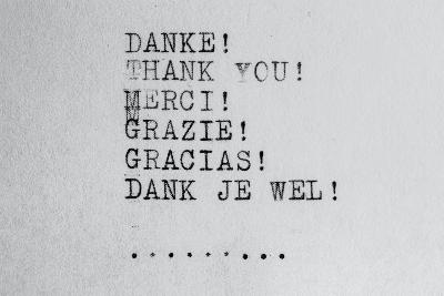 Blatt Papier mit Dankeschön in mehreren Sprachen mit Schreibmaschine geschrieben