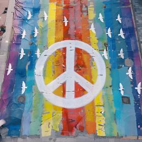 Friedenszeichen vor Regenbogenflagge