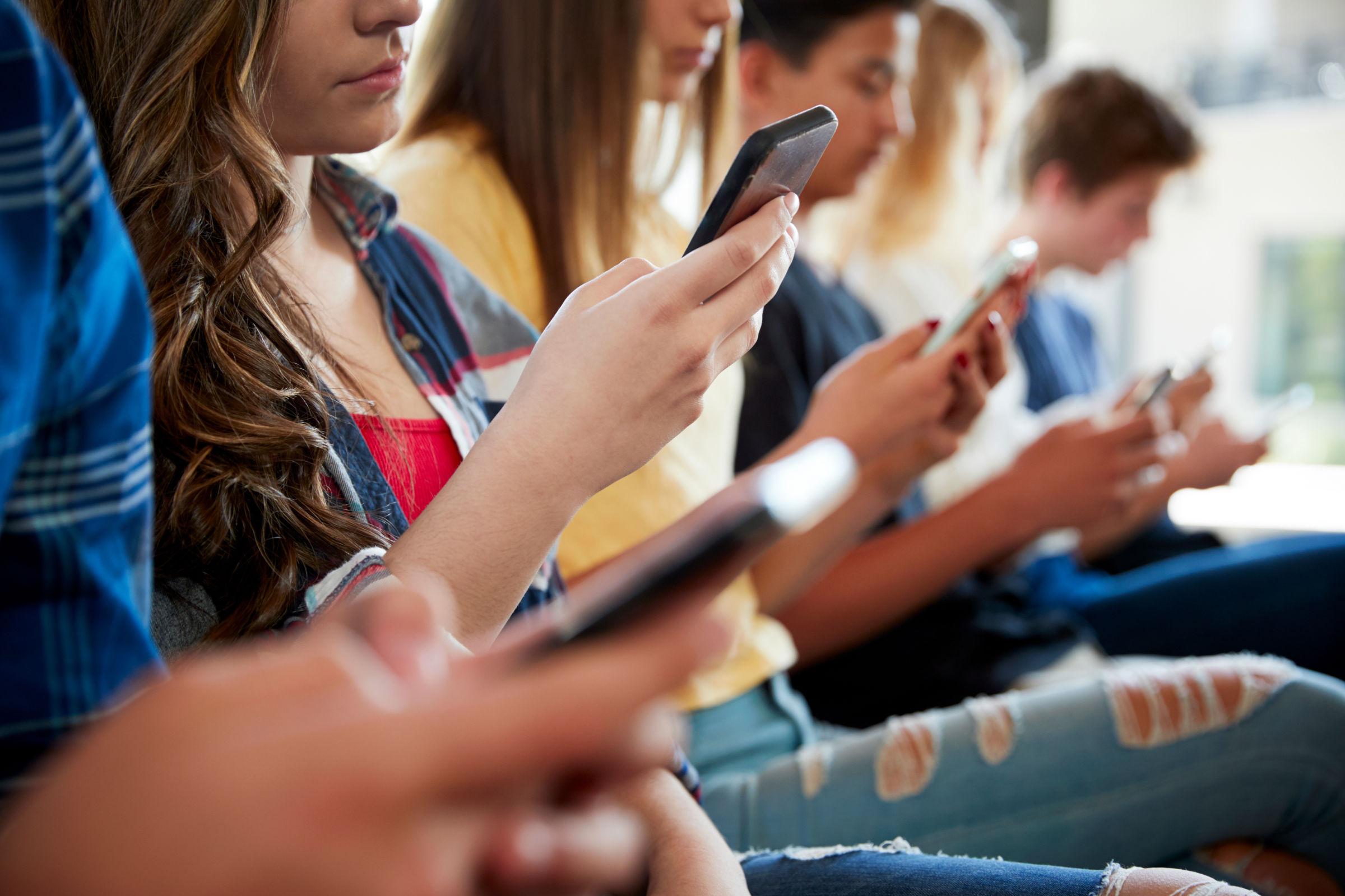 Jugendliche schauen auf ihr Smartphone