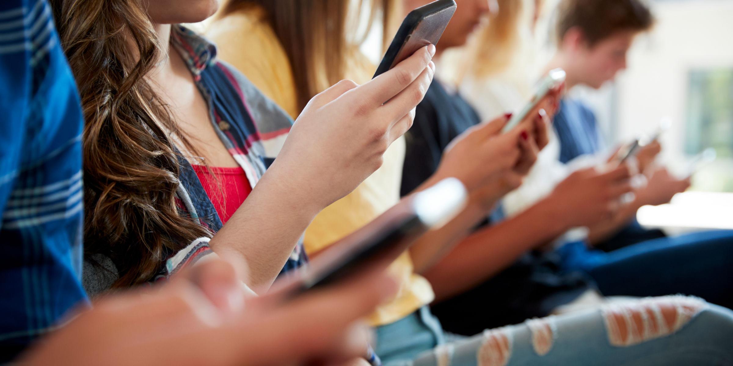 Jugendliche schauen auf ihr Smartphone
