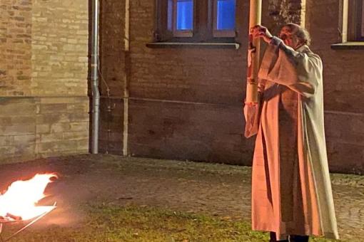 Pfr Winfiried Hommel mit der frisch entzündeten Osterkerze am Osterfeuer auf dem Jakobsberg
