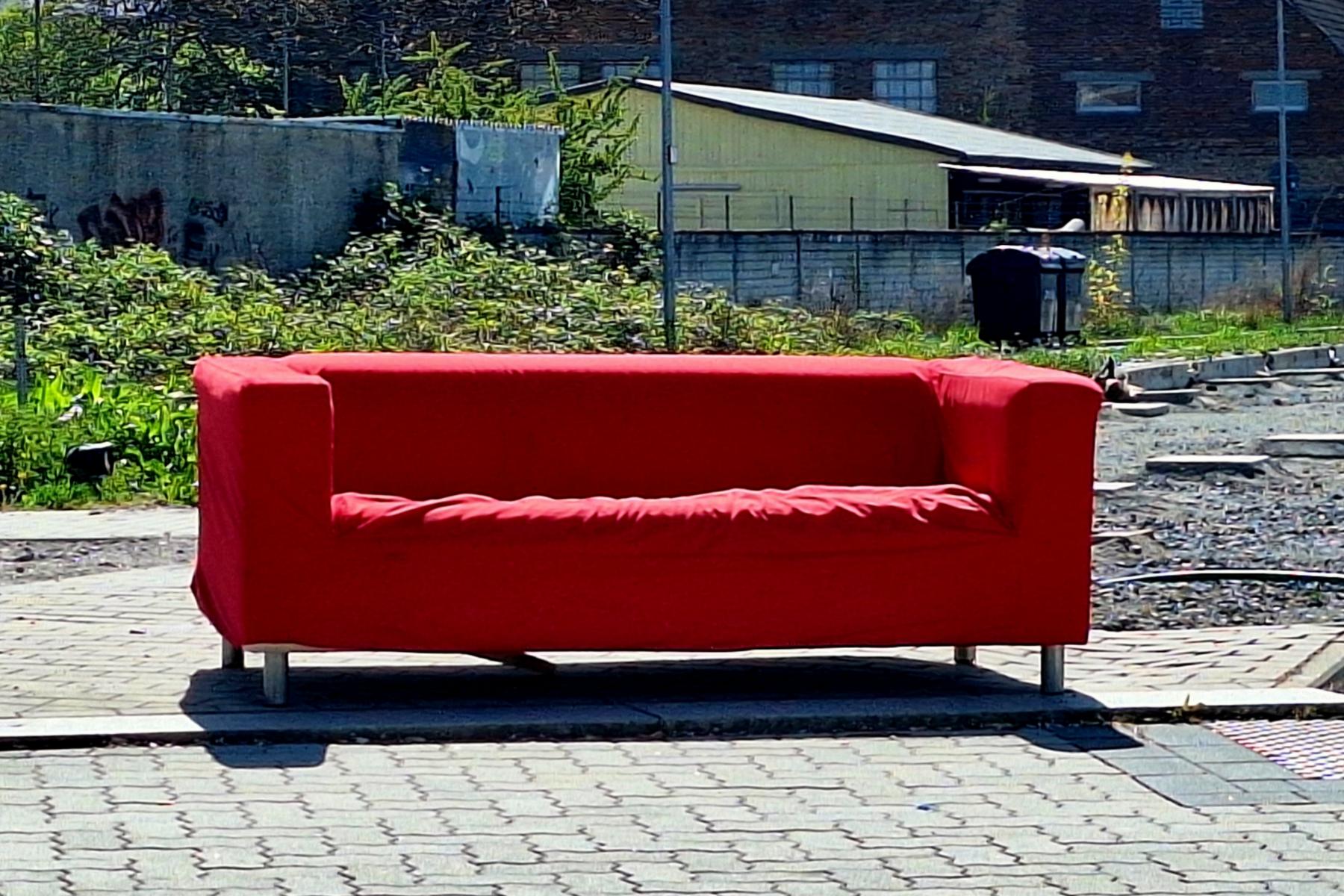 rotes Sofa auf dem Bürgersteig
