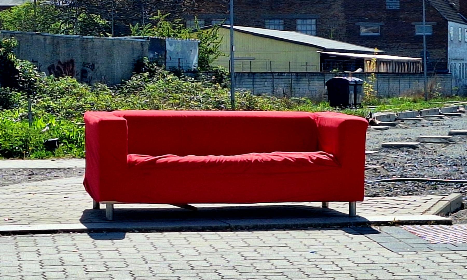 rotes Sofa auf dem Bürgersteig
