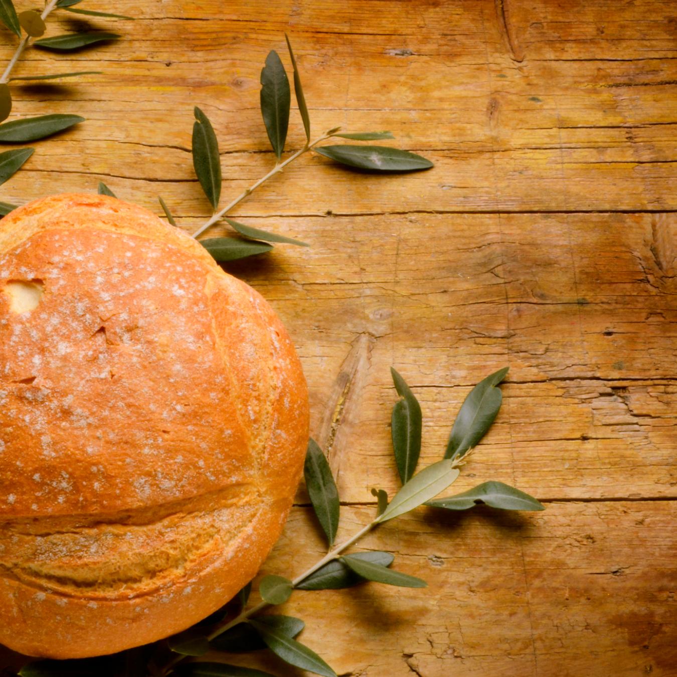 Brot auf Buchsbaumzweigen auf Holzuntergrund