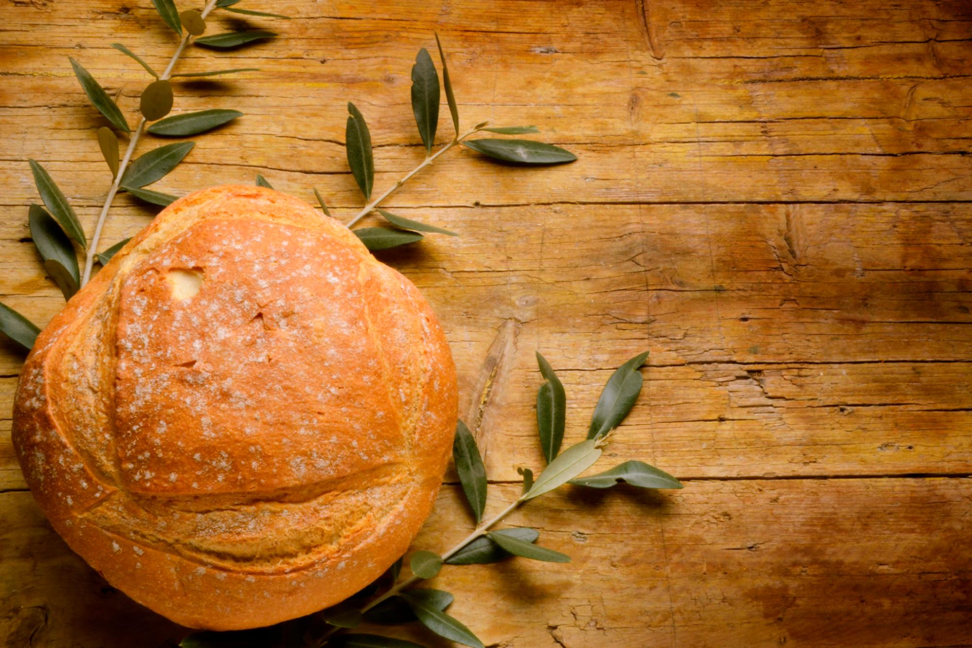 Brot auf Buchsbaumzweigen auf Holzuntergrund