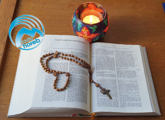 Bibel mit Rosenkranz und Kerze