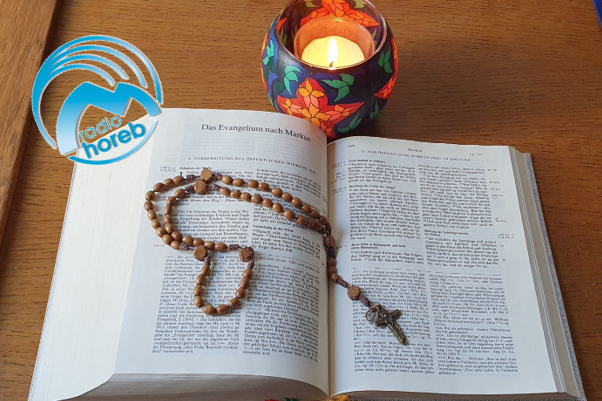 Bibel mit Rosenkranz und Kerze