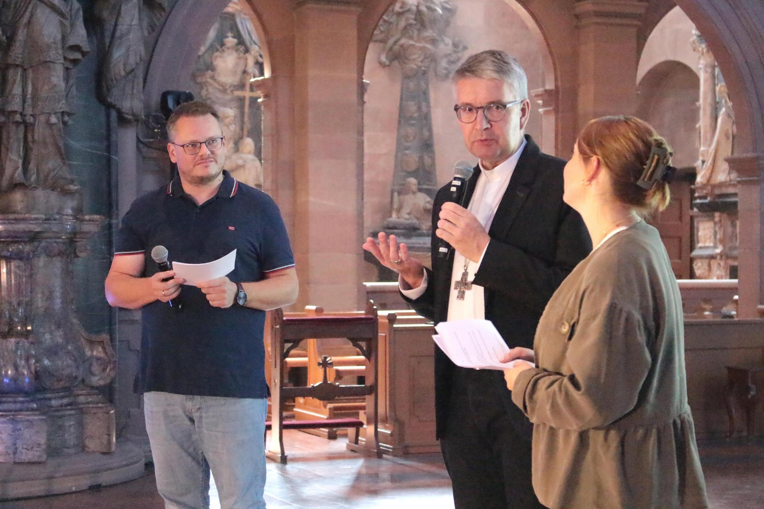 Bischof Kohlgraf im Gespräch mit den Moderator*innen Michael Langer (li) und Ann-Kathein Mashall (re)