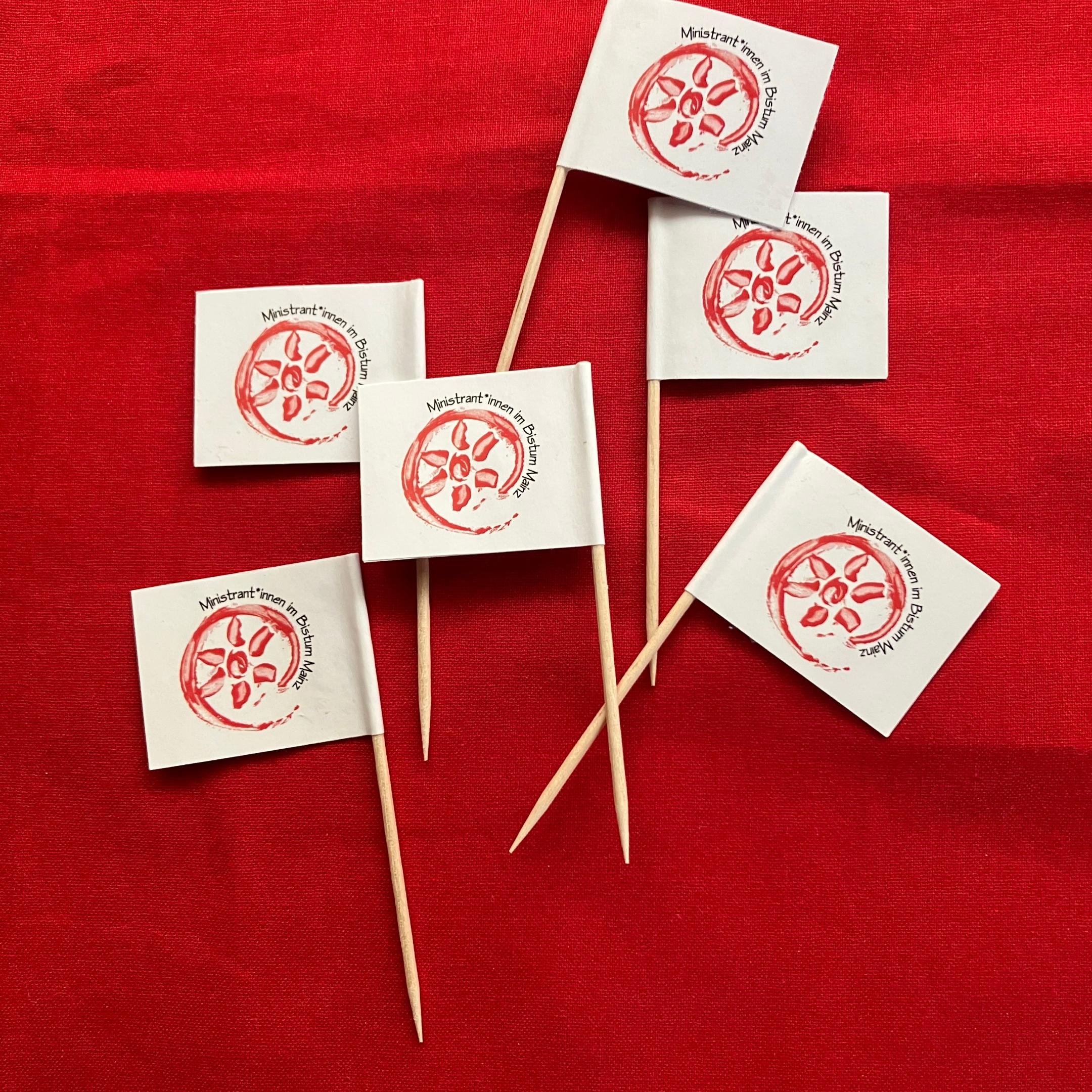 Auf dem Bild sind kleine Fähnchen mit dem Mini-Logo abgebildet. Diese kann man zum Beispiel als Dekoration auf Muffins oder ähnliches einsetzen.
