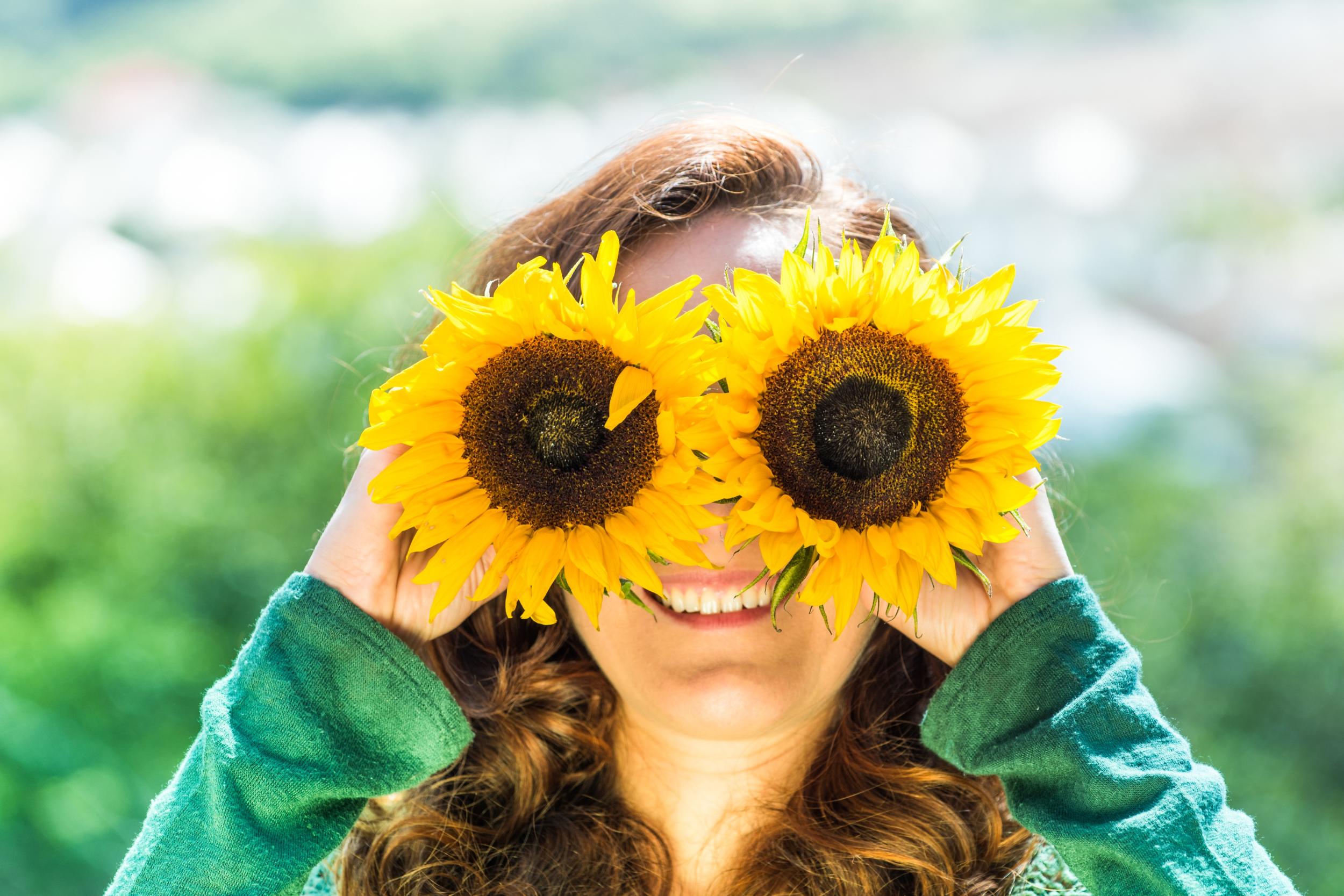 Junge Frau mit Sonnenblumen-Brille