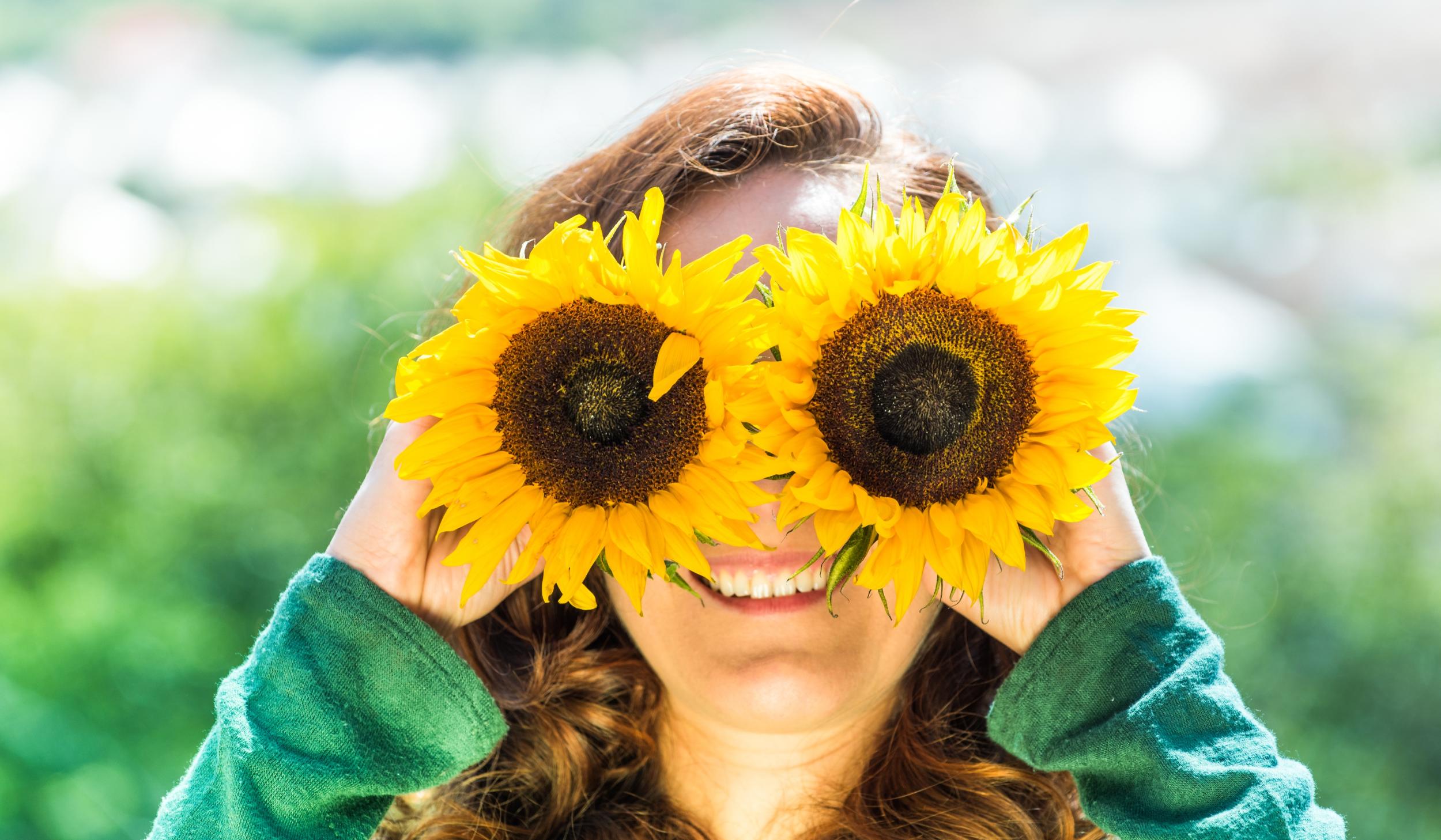 Junge Frau mit Sonnenblumen-Brille