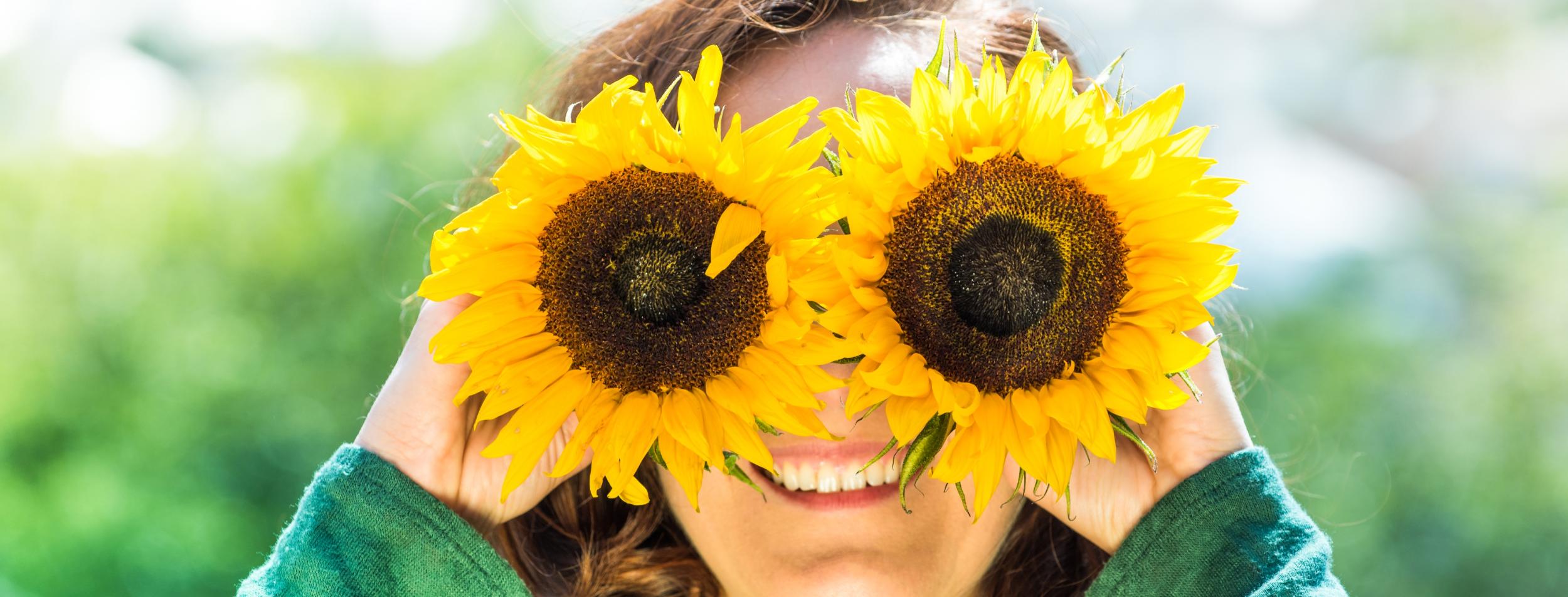 Junge Frau mit Sonnenblumen-Brille
