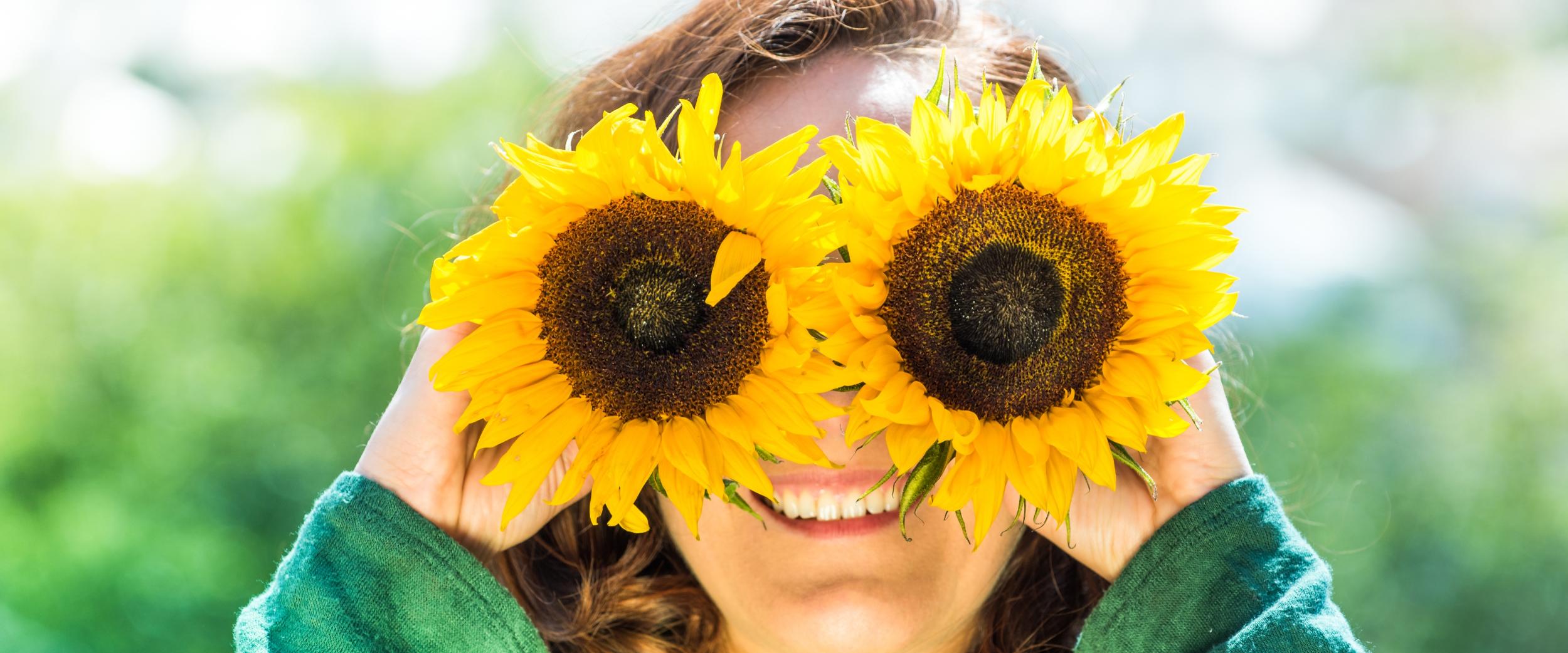 Junge Frau mit Sonnenblumen-Brille