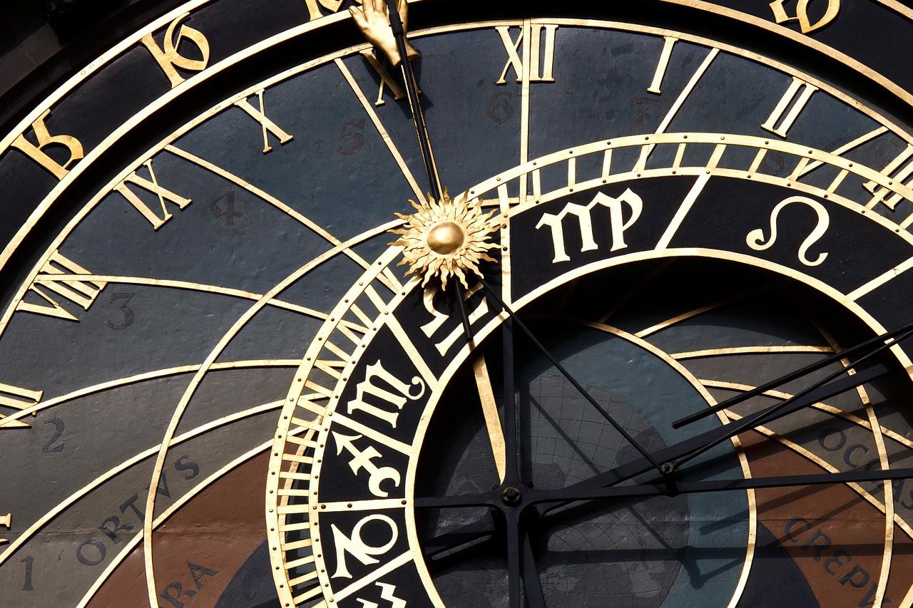 Astronomische Uhr mit goldenen Ziffern und Zeigern auf dunklem Hintergrund