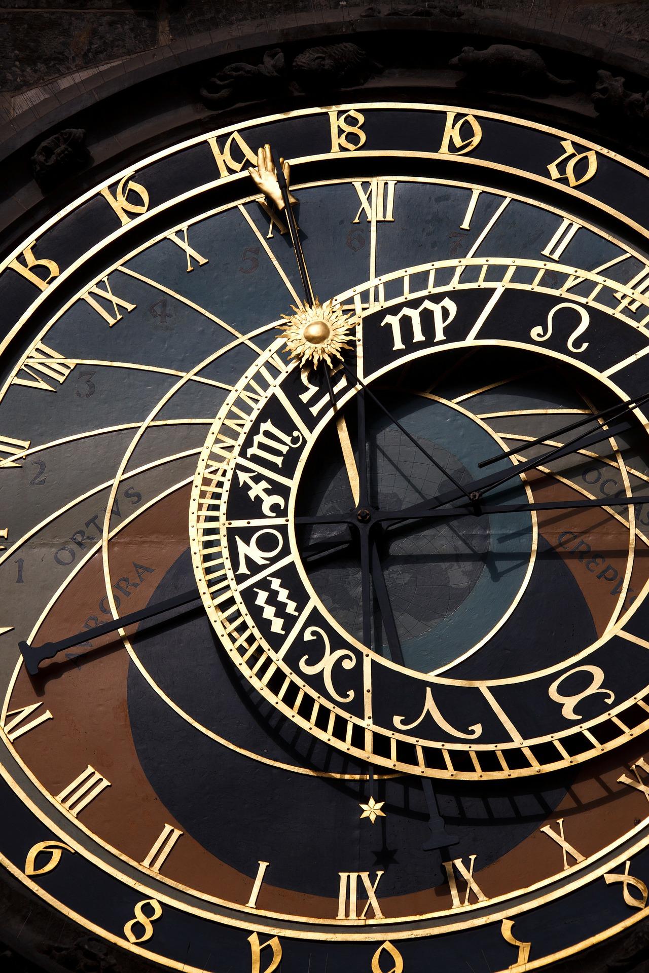 Astronomische Uhr mit goldenen Ziffern und Zeigern auf dunklem Hintergrund