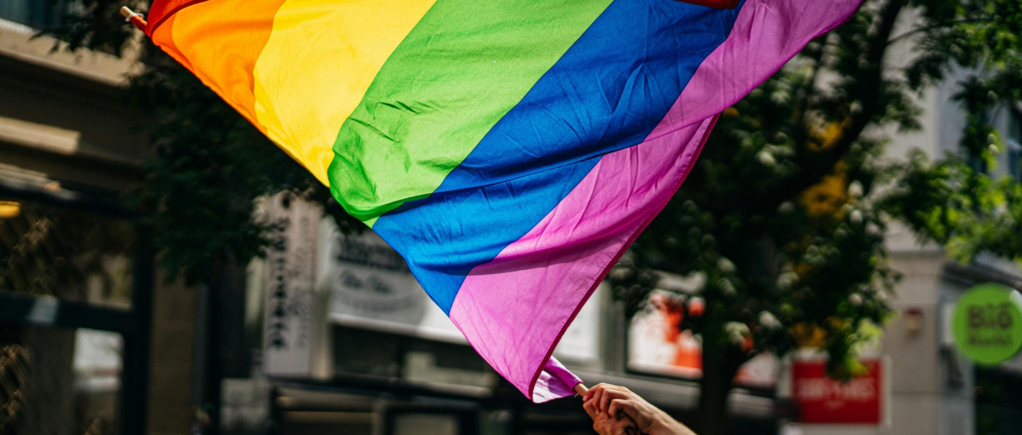 Es wird eine LGBTQI+ flagge geschwnkt