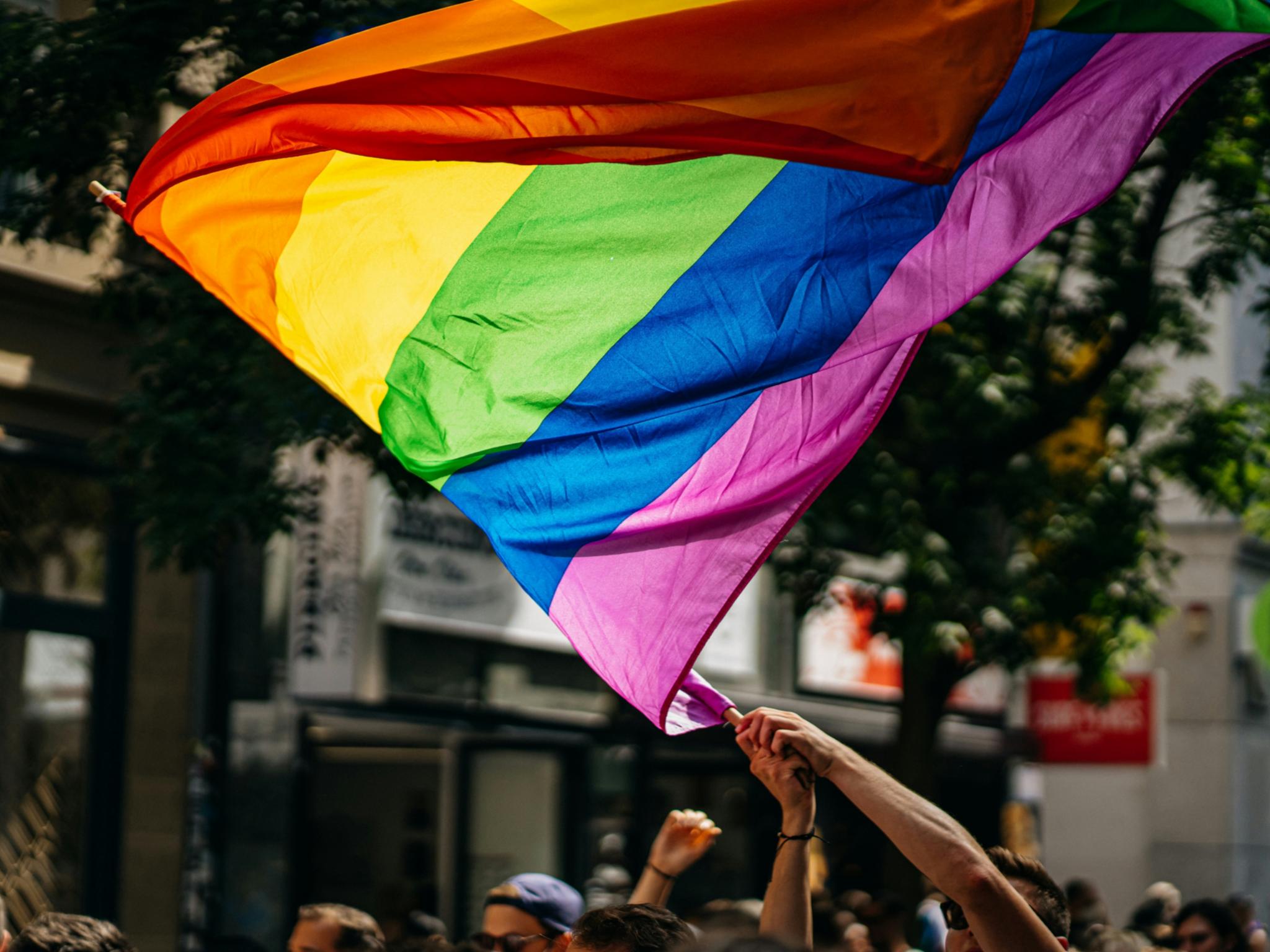 Es wird eine LGBTQI+ flagge geschwnkt